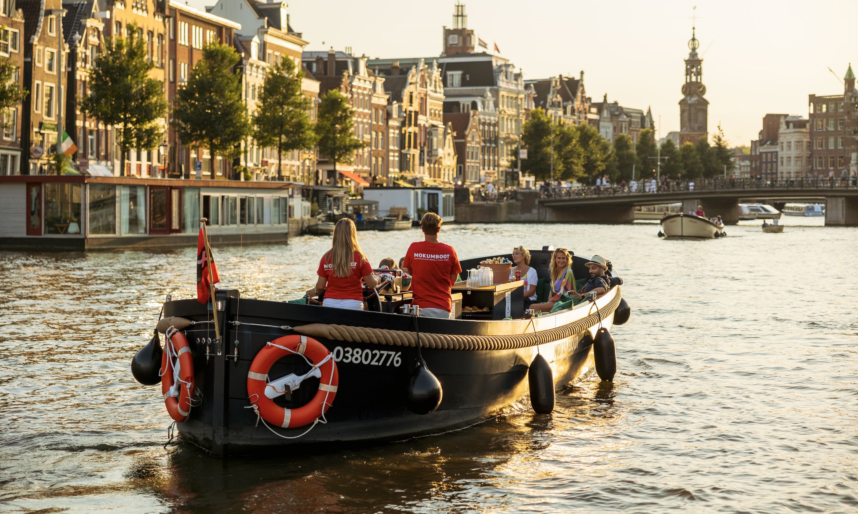 Barco Mokumboot pasando por la Munt en los canales de Ámsterdam